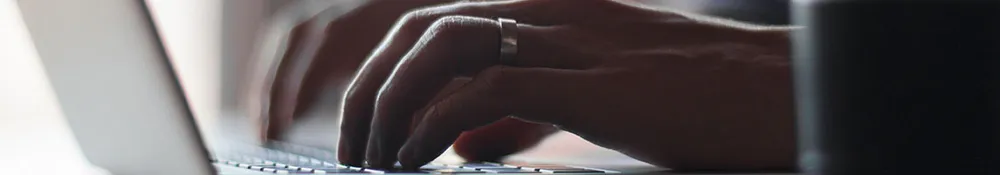 A hand typing on a keyboard