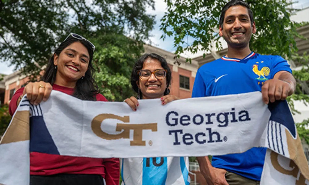 (L-R): Sindhu Belki, Irene Jacob, and Alex Duncan show off a Georgia Tech soccer scarf.