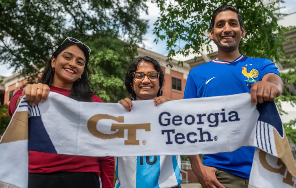 (L-R): Sindhu Belki, Irene Jacob, and Alex Duncan show off a Georgia Tech soccer scarf.