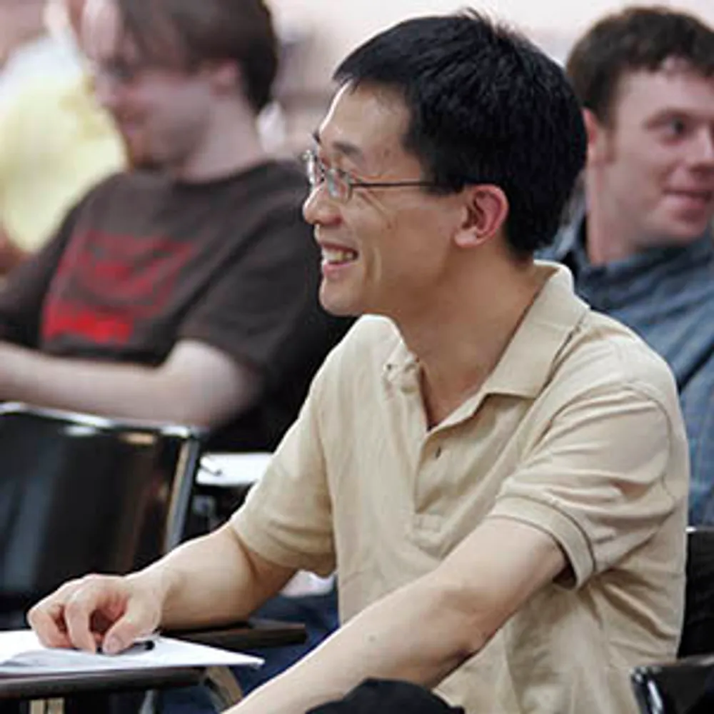 A student sitting at a desk smiling